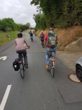 Eine Fahrradparade fährt hinterm Trecker her.