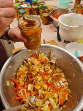 Hier wird das gemischte, kleingeschnittene und mit der Kimchi-Paste vermischte Gemüse in Gläser abgefüllt.